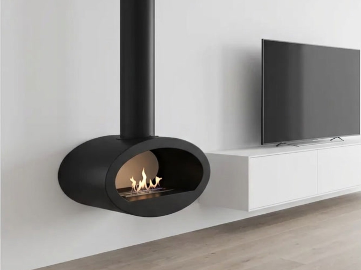 Zwarte hangende bio-ethanol haard met echte vlam aan een witte wand, naast een zwevend tv-meubel